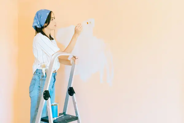 Interior painting in Little Rock: painter on a stepladder rolling a wall